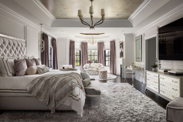 A spacious bedroom with a chandelier above a neatly made bed