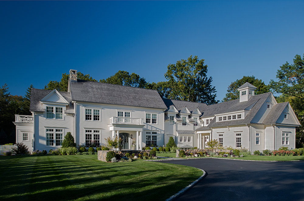 A large white house with a spacious driveway leading up to the entrance